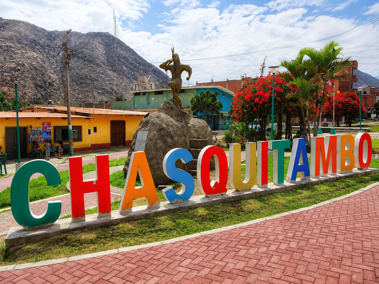 Letras monumentales de Chasquitambo en la plaza, con la estatua del chasqui sobre la roca y los cerros del valle al fondo
